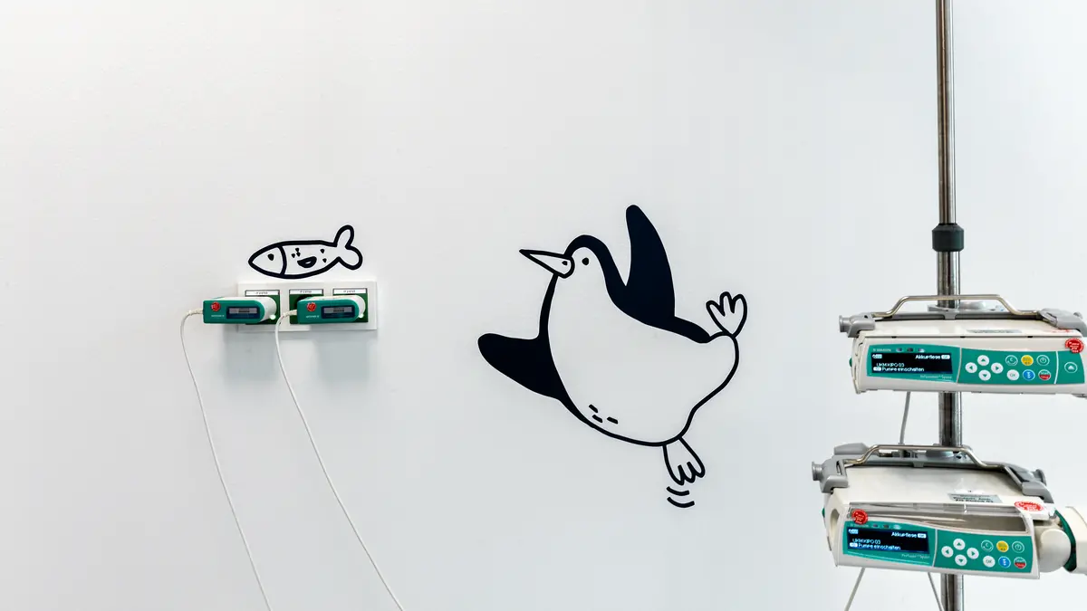 Projekte_UKM_IEZ_Münster_Patientenzimmer_Pinguin mit Fisch